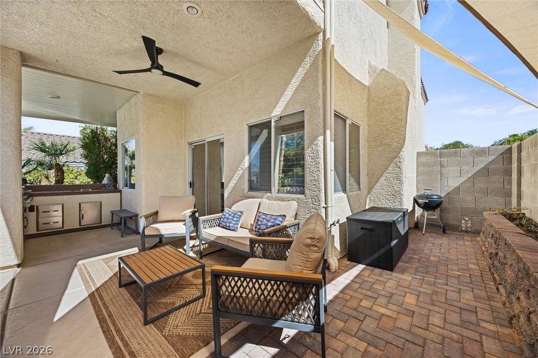 1421 Dragon Rock Drive, Henderson, NV 89052 A covered concrete terrace transitions seamlessly into a brick-paved patio under sunny skies.