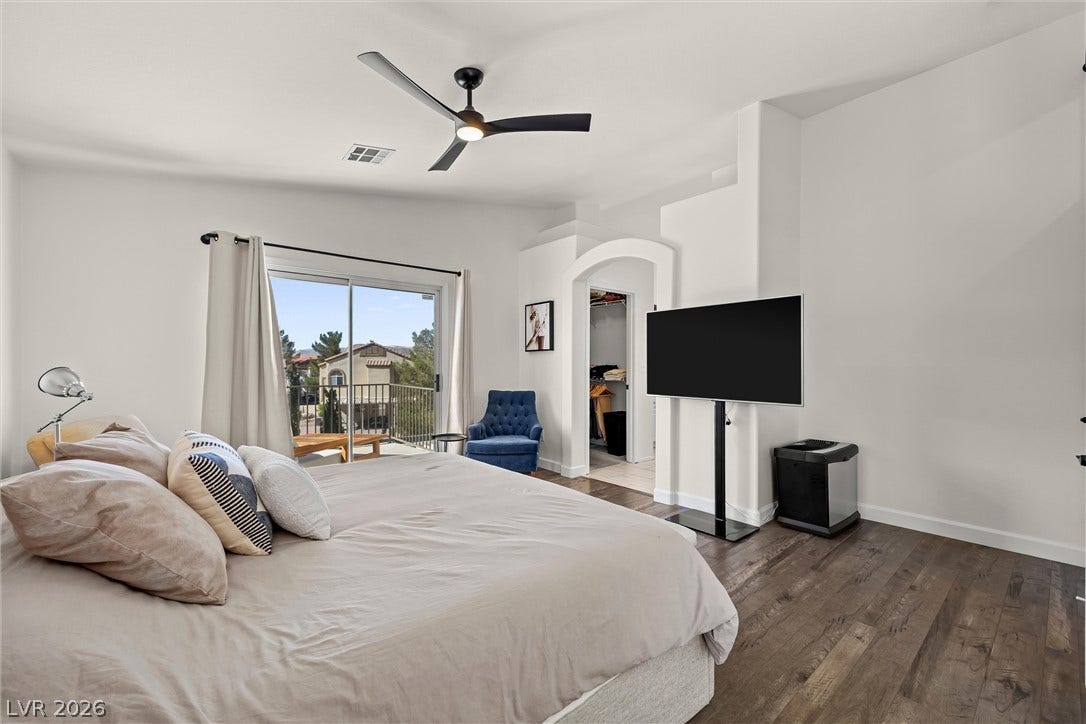 1421 Dragon Rock Drive, Henderson, NV 89052 Rich wood flooring runs throughout this spacious bedroom with glass doors opening to a private balcony.