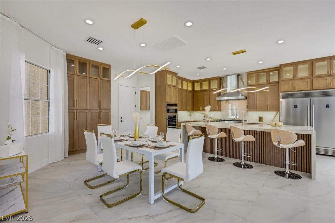 5015 Rivedro Street, Las Vegas, NV 89135 Streamlined cabinetry and expansive stone tile flooring define this modern open-concept kitchen space.