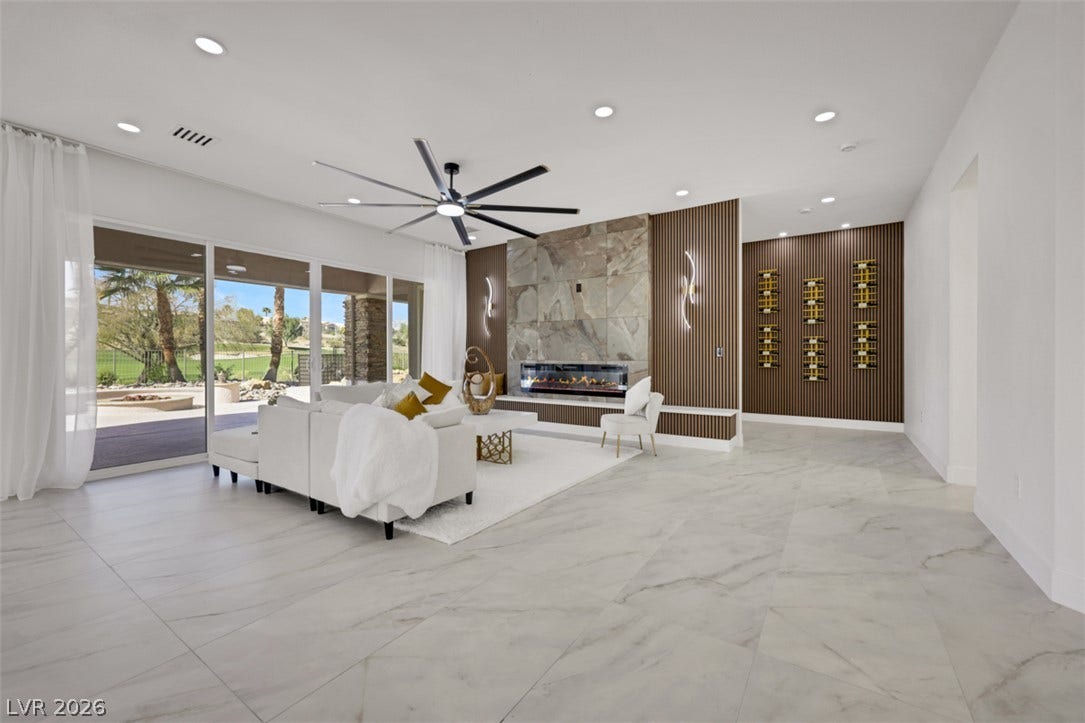 5015 Rivedro Street, Las Vegas, NV 89135 Sliding glass doors open to the patio from this modern living space with tile flooring.