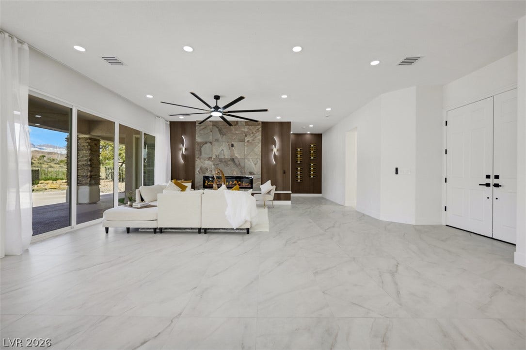 5015 Rivedro Street, Las Vegas, NV 89135 Polished stone floors and sliding glass doors define this expansive open living space.