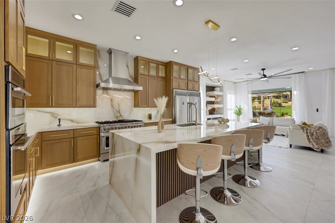 5015 Rivedro Street, Las Vegas, NV 89135 Warm wood cabinetry and elegant stone counters anchor this bright culinary space.