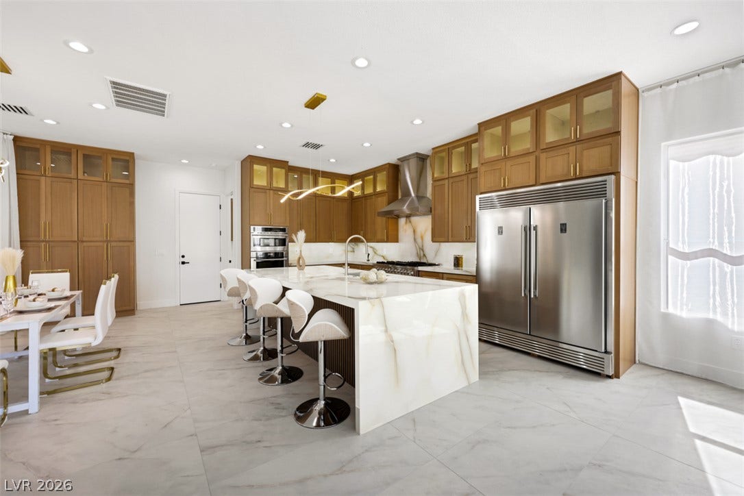 5015 Rivedro Street, Las Vegas, NV 89135 Gleaming stone countertops and matching flooring anchor this modern open culinary space.