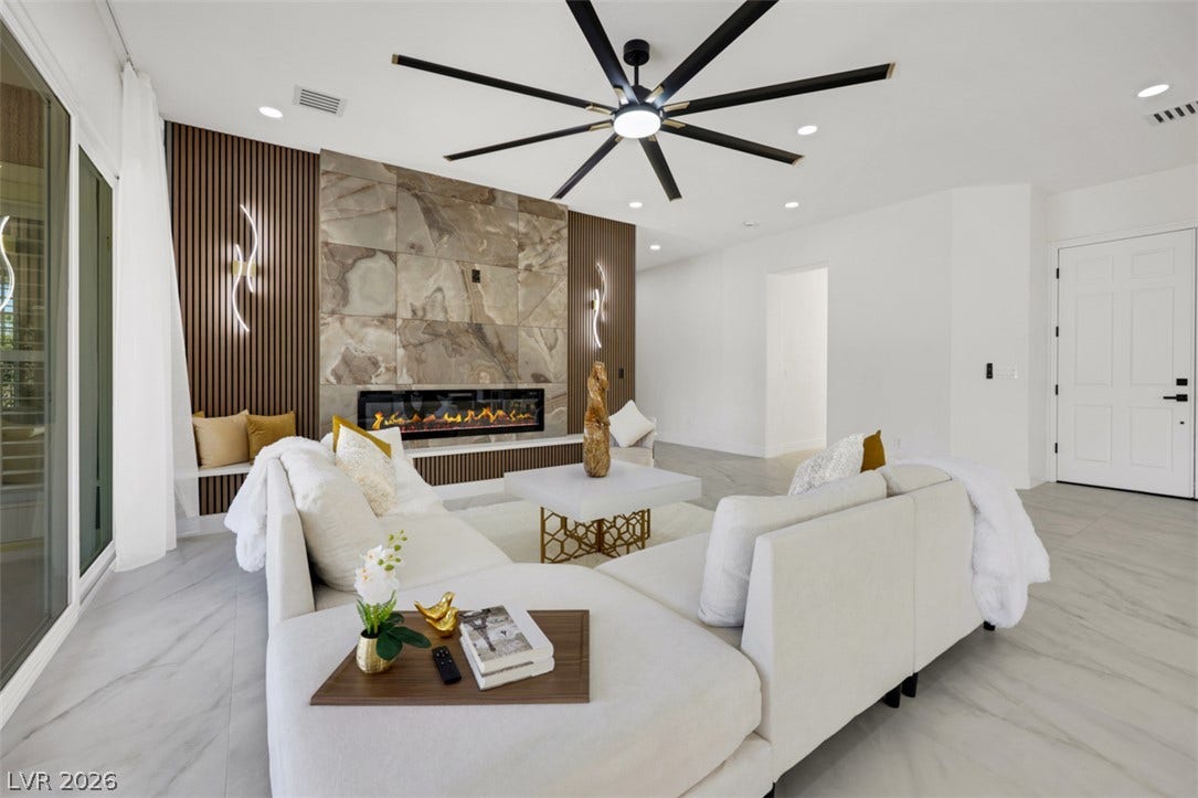 5015 Rivedro Street, Las Vegas, NV 89135 An elegant modern fireplace serves as the centerpiece of this light-filled living area.