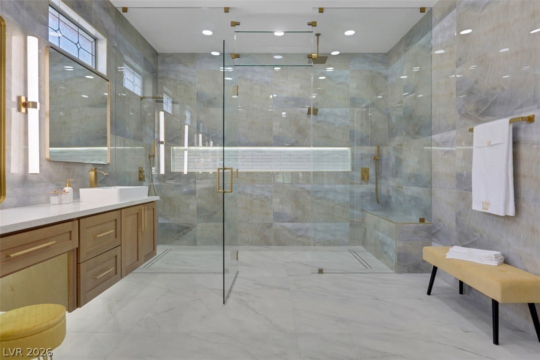 5015 Rivedro Street, Las Vegas, NV 89135 Gleaming marble tile floors pair with a massive glass-enclosed shower in this luxurious modern bath.
