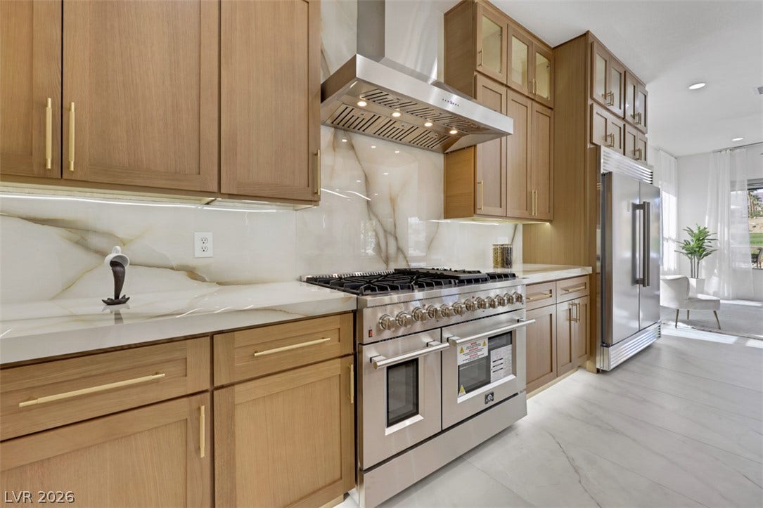 5015 Rivedro Street, Las Vegas, NV 89135 Warm wood cabinetry pairs with elegant stone countertops and premium stainless steel appliances.