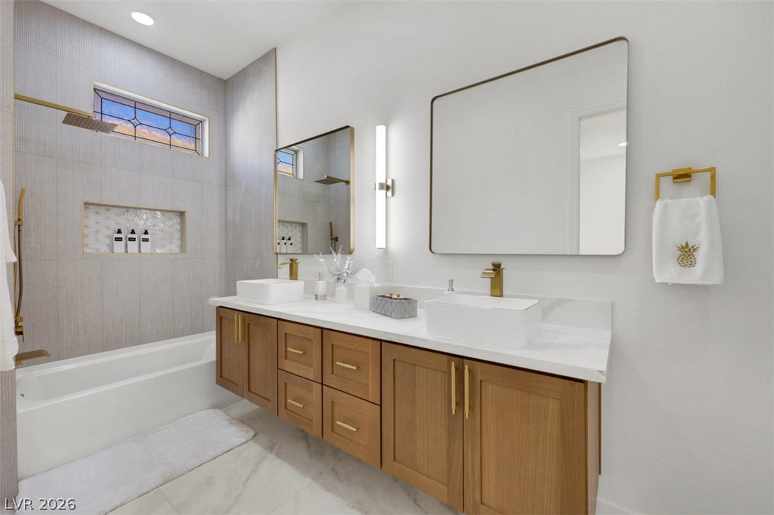 5015 Rivedro Street, Las Vegas, NV 89135 A floating wood vanity pairs with marble-style flooring in this contemporary bathroom.