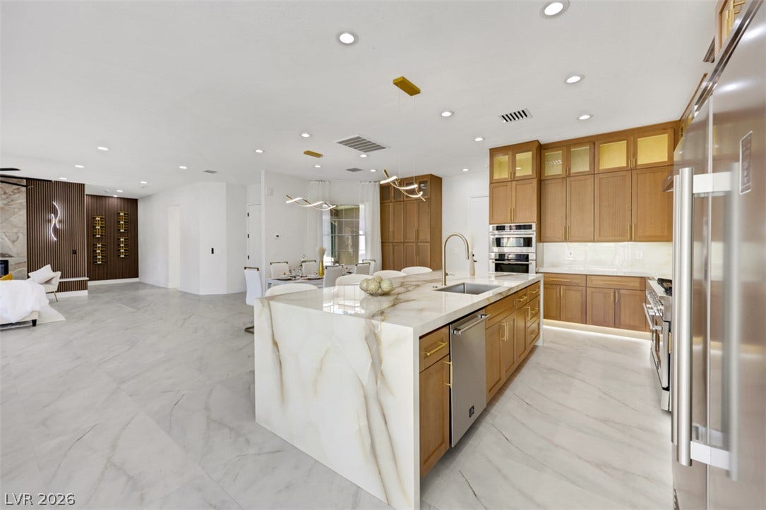 5015 Rivedro Street, Las Vegas, NV 89135 Gleaming marble floors and premium stone countertops define this elegant, open-concept culinary space.