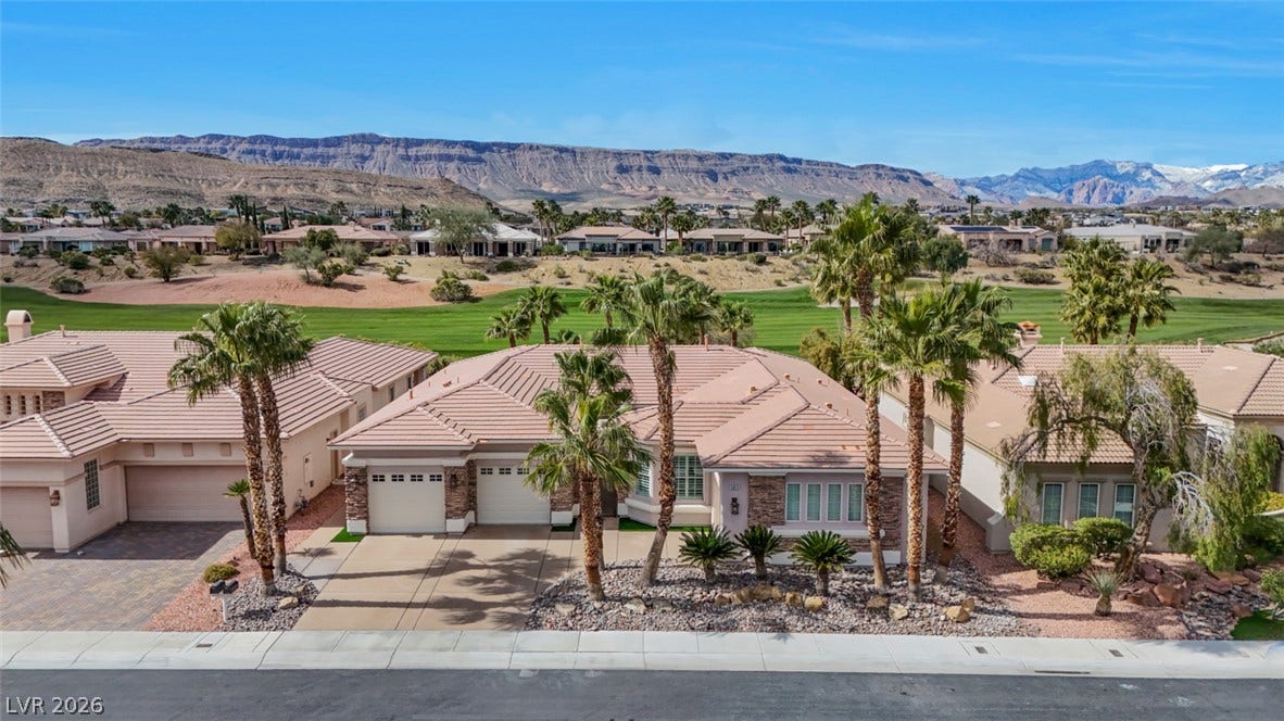 5015 Rivedro Street, Las Vegas, NV 89135 Palm trees frame a stone-accented exterior set against a golf course backdrop.
