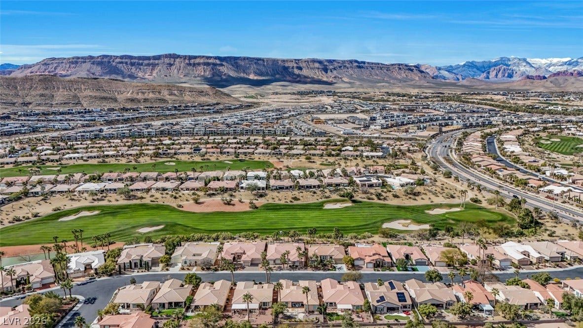5015 Rivedro Street, Las Vegas, NV 89135 Dramatic mountain ridges frame an expansive golf course green winding through the residential community.