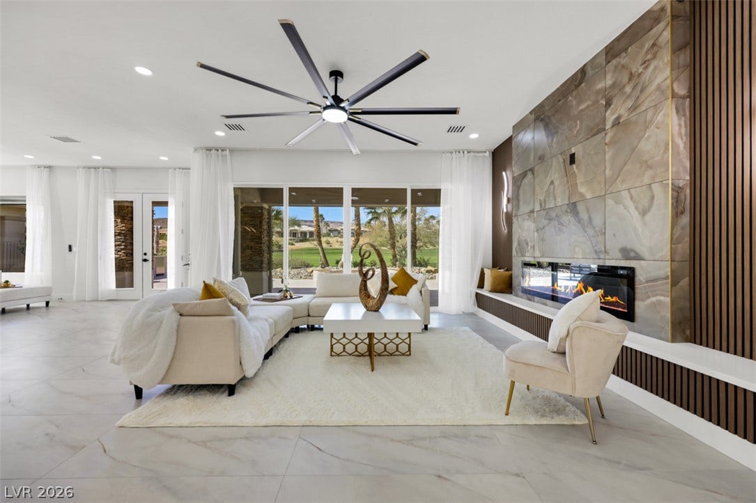 5015 Rivedro Street, Las Vegas, NV 89135 A magnificent stone-clad fireplace and expansive sliding glass doors anchor this airy open space.