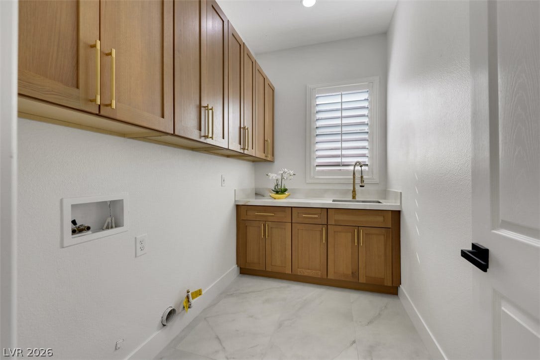 5015 Rivedro Street, Las Vegas, NV 89135 A functional workspace features warm wood cabinetry, a utility sink, and durable tile flooring.