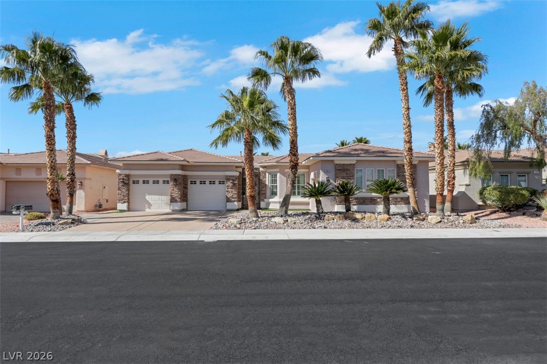5015 Rivedro Street, Las Vegas, NV 89135 Palm trees frame this contemporary desert home featuring a tiled roof and stone accents.