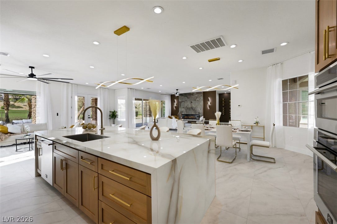 5015 Rivedro Street, Las Vegas, NV 89135 Polished tile flooring and an expansive stone-waterfall island anchor this modern open floorplan.