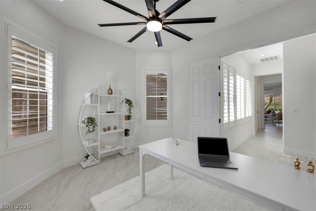5015 Rivedro Street, Las Vegas, NV 89135 Crisp white finishes and plantation shutters elevate this modern workspace.