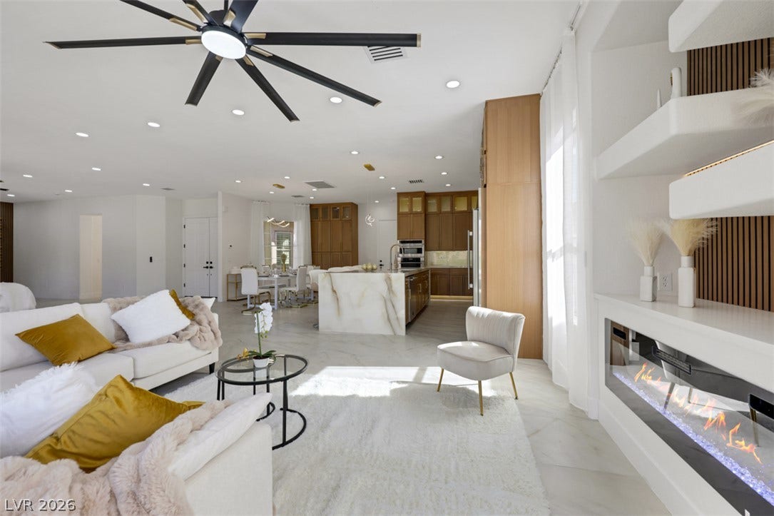 5015 Rivedro Street, Las Vegas, NV 89135 An open floorplan seamlessly connects the living space with a modern fireplace to the kitchen.