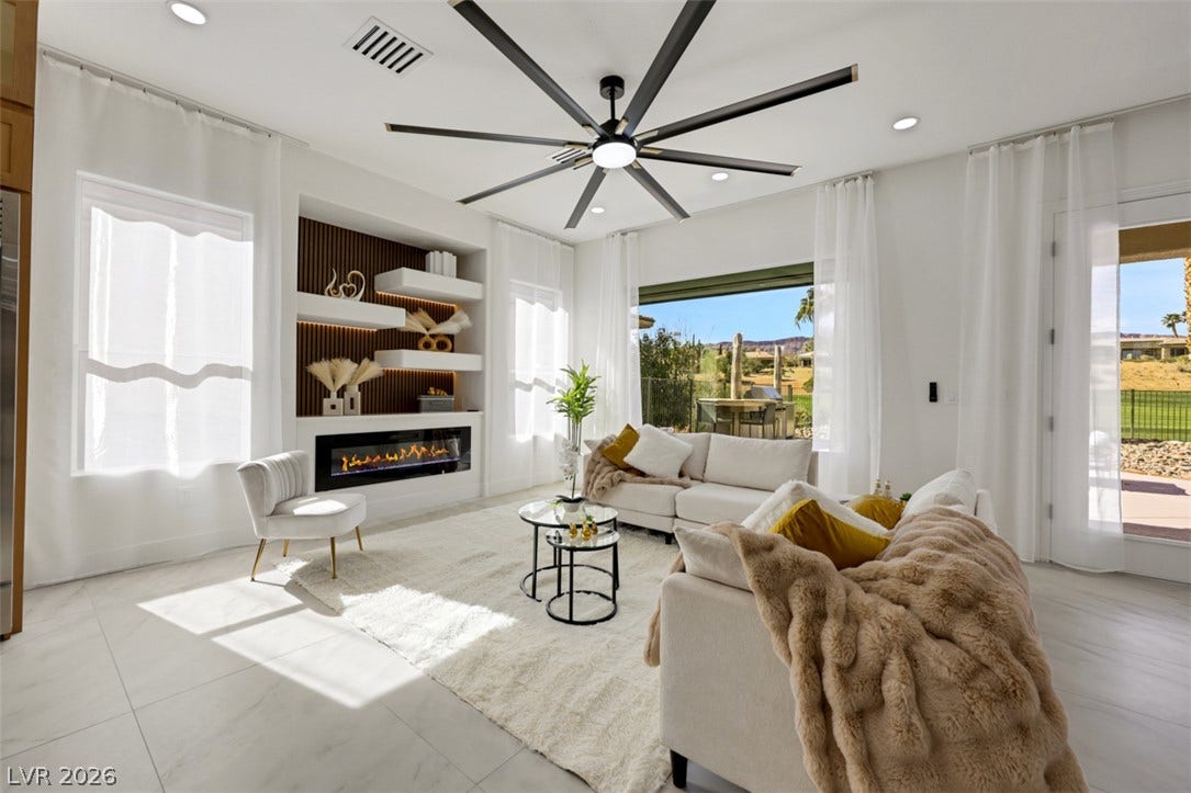 5015 Rivedro Street, Las Vegas, NV 89135 Sunlight pours across tile floors in an airy living space with a modern linear fireplace.