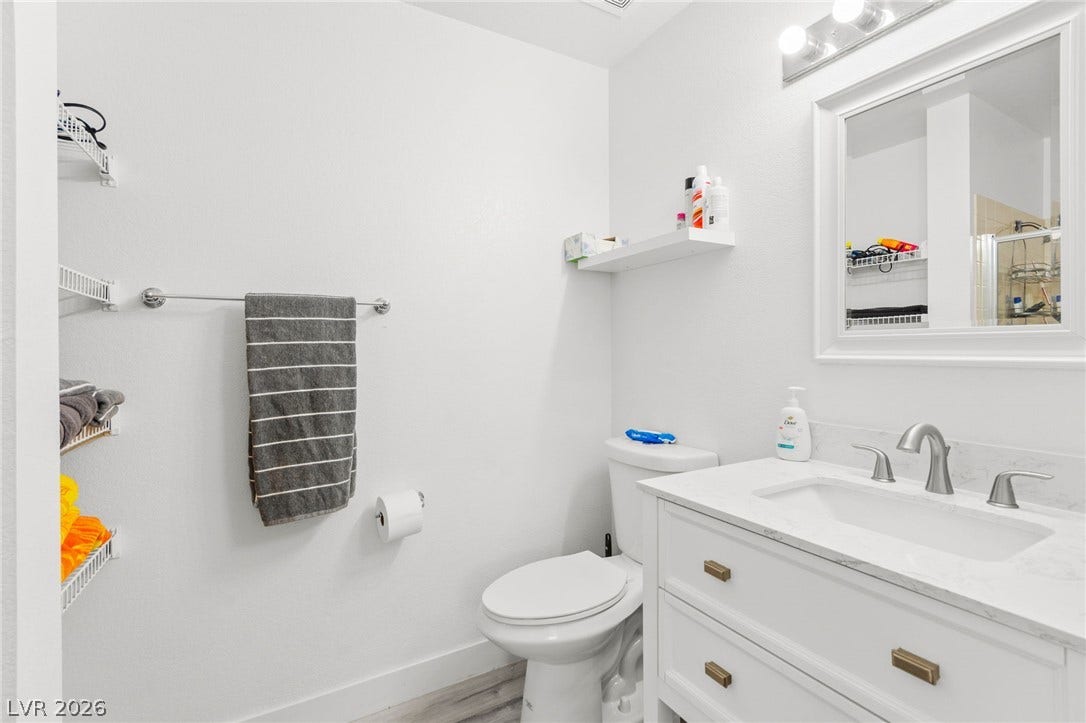 2200 S Fort Apache Road, #2156, Las Vegas, NV 89117 A well-lit primary bathroom featuring a modern vanity with brushed nickel fixtures and a spacious mirror.
