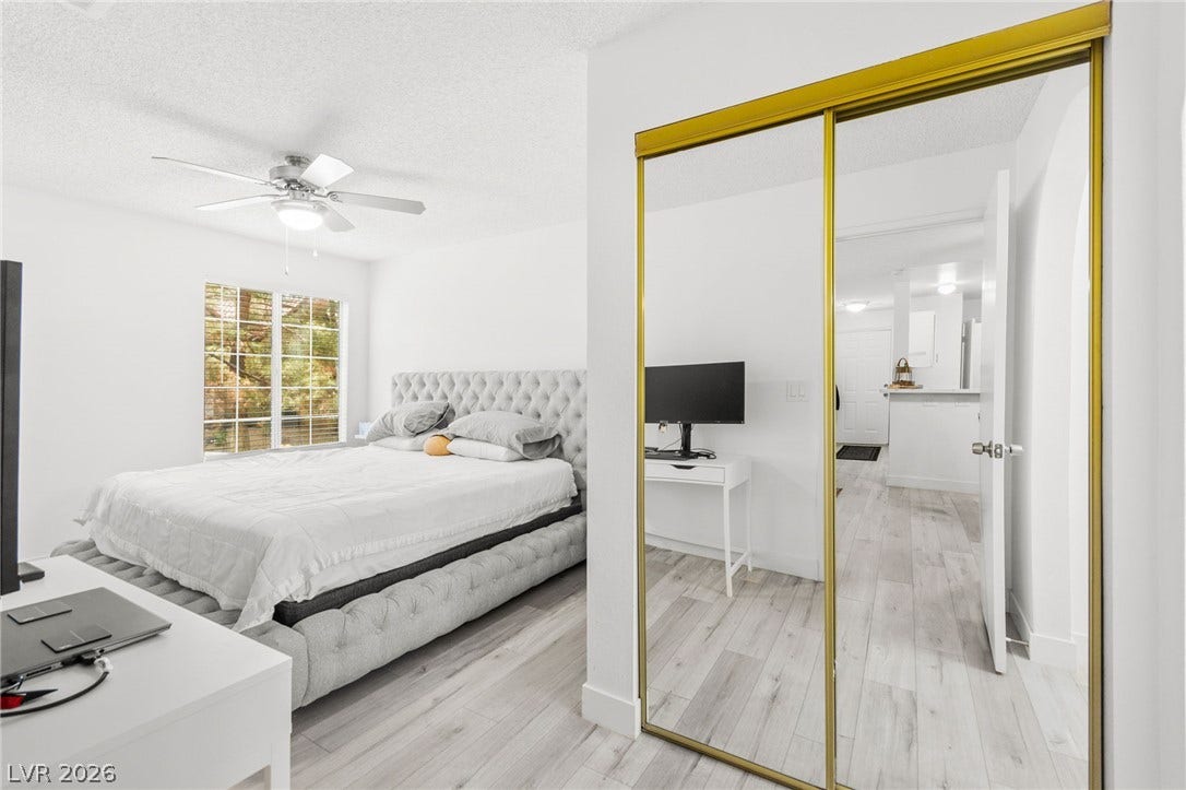 2200 S Fort Apache Road, #2156, Las Vegas, NV 89117 Bright and airy sleeping quarters feature a window with natural light, complementing the wood-look flooring.