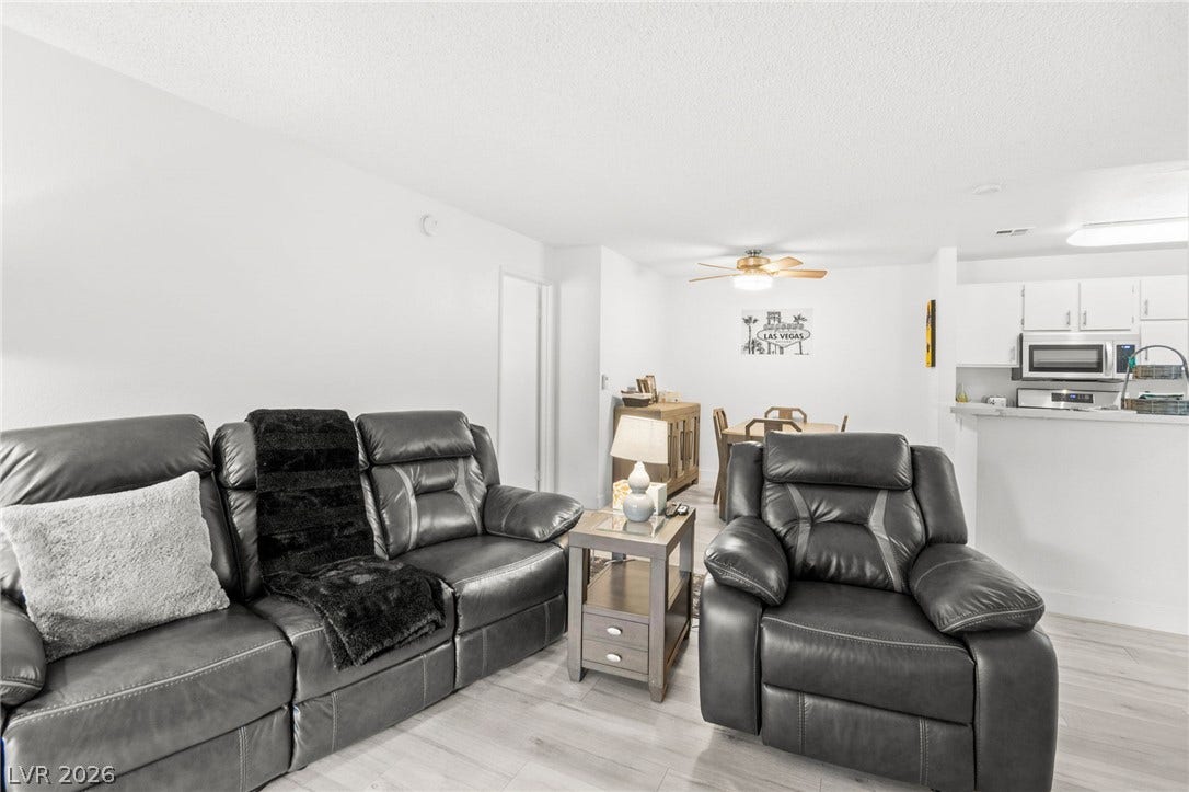 2200 S Fort Apache Road, #2156, Las Vegas, NV 89117 Relax in this living room, featuring a light wood-look flooring and an open flow into the dining space.