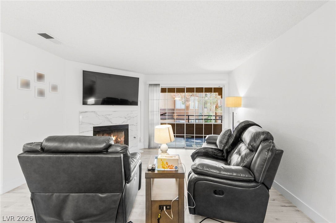 2200 S Fort Apache Road, #2156, Las Vegas, NV 89117 A comforting fireplace hearth with elegant marble surround anchors this inviting living space.