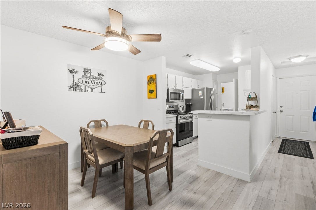 2200 S Fort Apache Road, #2156, Las Vegas, NV 89117 An inviting dining area flows seamlessly into a well-appointed kitchen, featuring a practical breakfast bar.