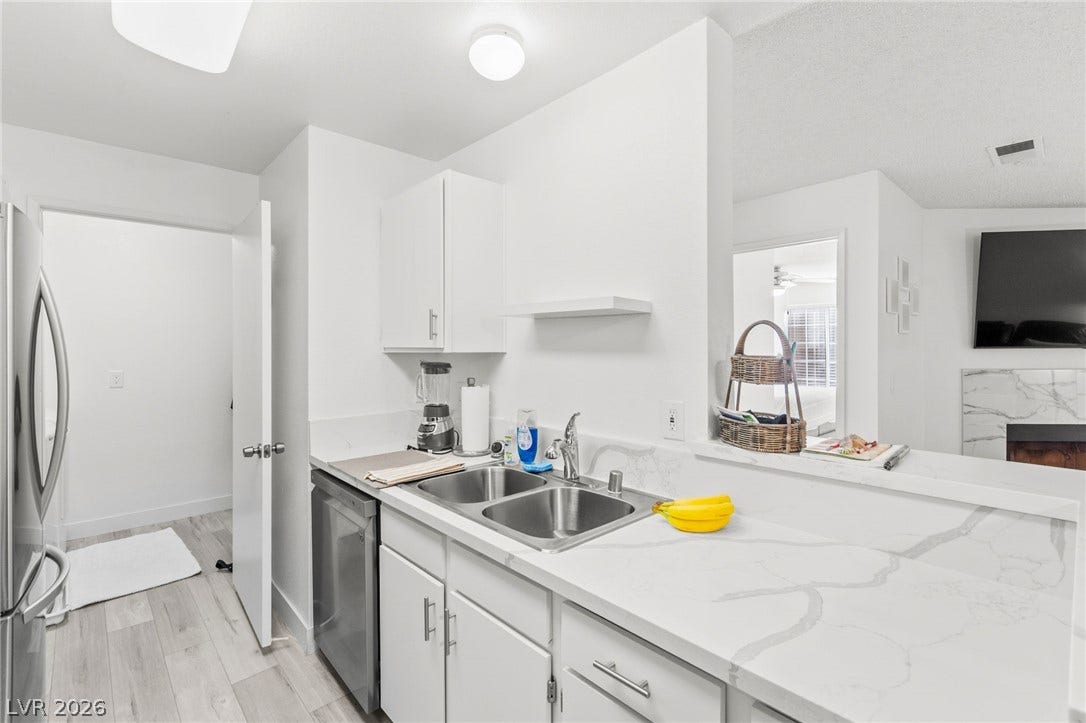 2200 S Fort Apache Road, #2156, Las Vegas, NV 89117 A well-lit kitchen with sleek white cabinetry and resilient flooring.
