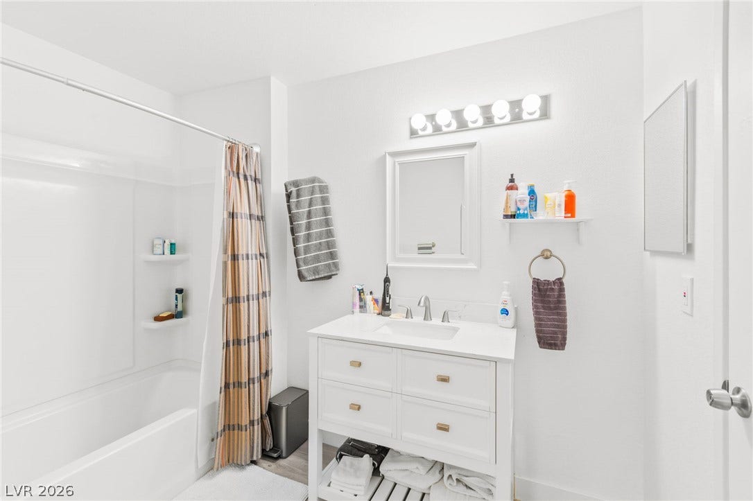 2200 S Fort Apache Road, #2156, Las Vegas, NV 89117 A well-appointed bathroom offers a clean vanity with ample storage, a framed mirror, and a bathtub with an integrated shower.