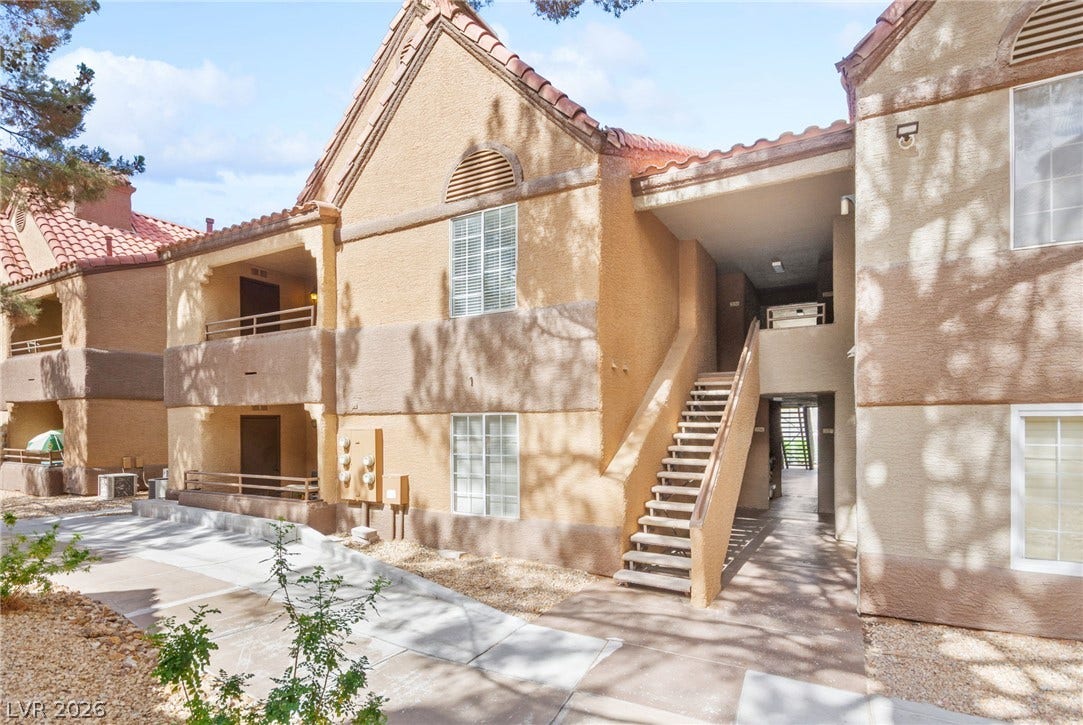 2200 S Fort Apache Road, #2156, Las Vegas, NV 89117 The complex presents a classic stucco facade with a traditional tiled roof and external stairs.
