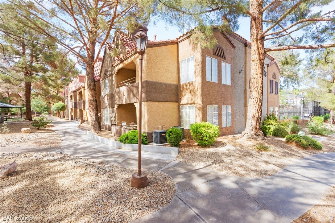 2200 S Fort Apache Road, #2156, Las Vegas, NV 89117 A terracotta-roofed apartment complex, nestled amidst mature pines, offers inviting outdoor spaces.