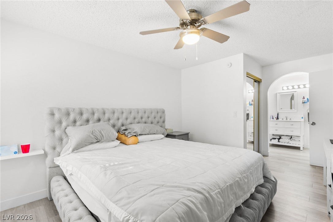 2200 S Fort Apache Road, #2156, Las Vegas, NV 89117 Relax in this tranquil bedroom, featuring light wood-style flooring and an elegant tufted headboard.