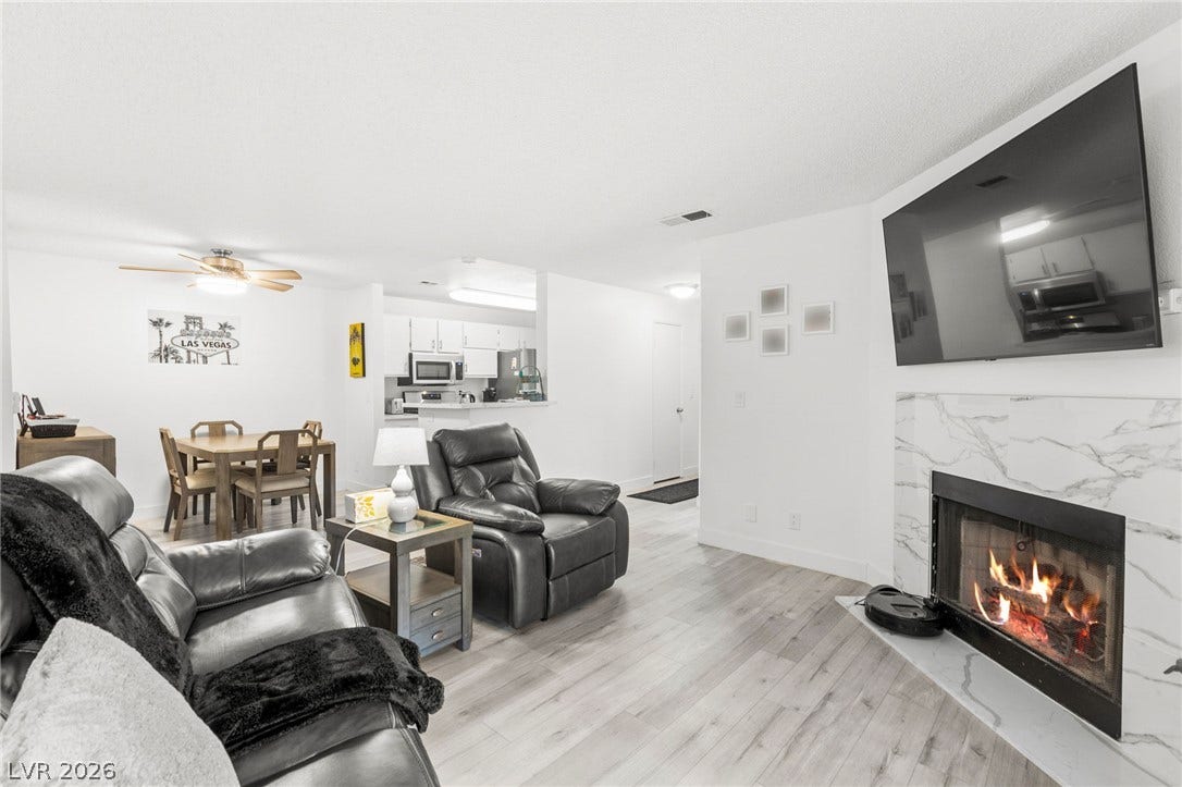 2200 S Fort Apache Road, #2156, Las Vegas, NV 89117 A luminous living space features a cozy fireplace and seamless flow to the dining area and kitchen.