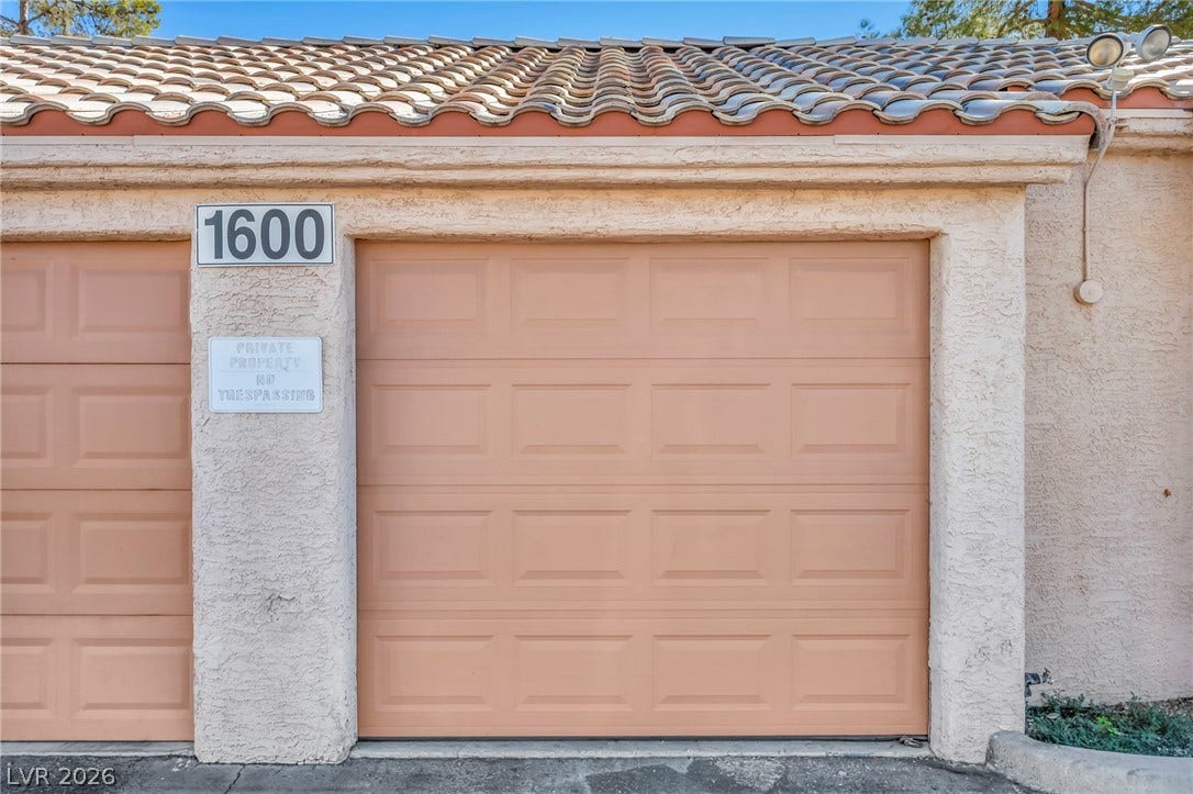A Spanish tile roof crowns the stucco exterior of this functional attached garage space.