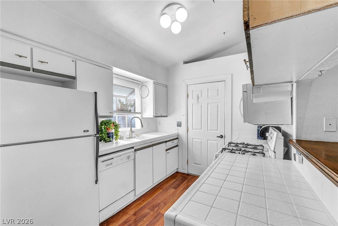 Gleaming hardwood floors and classic tile countertops define this functional kitchen workspace.