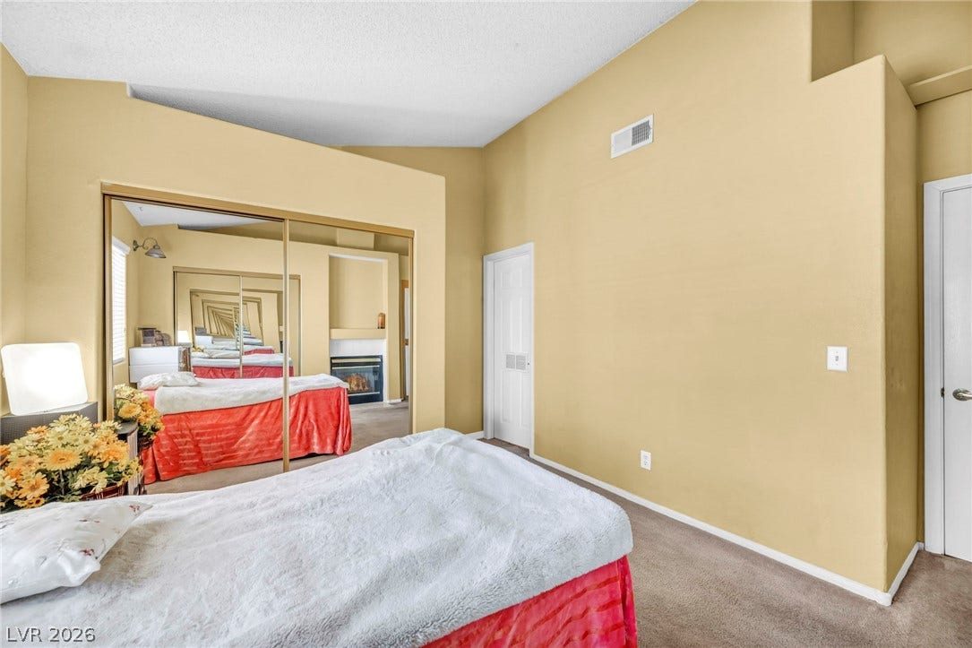 High vaulted ceilings and mirrored sliding doors maximize the architectural volume of this bedroom.