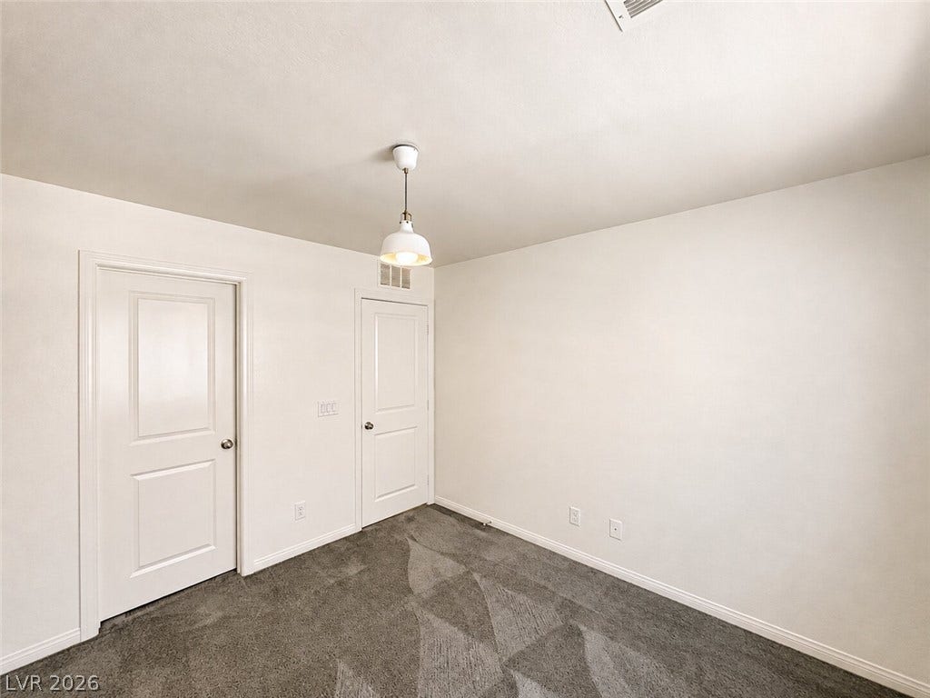 Patterned carpet and clean-lined doors bring a modern feel to this versatile secondary bedroom.