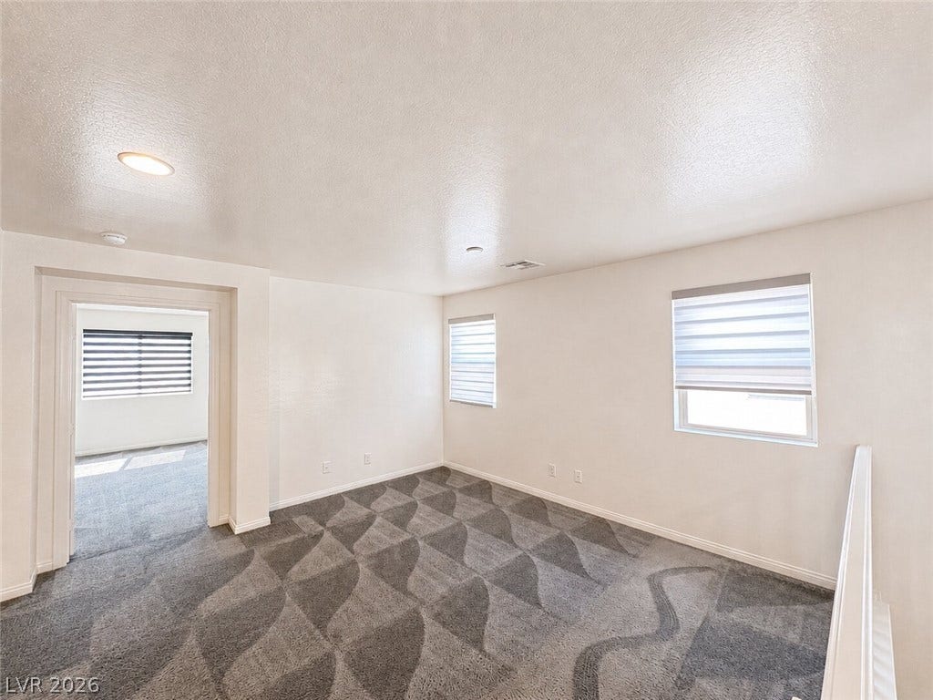 Patterned carpeting and recessed lighting define this versatile upper-level loft space.