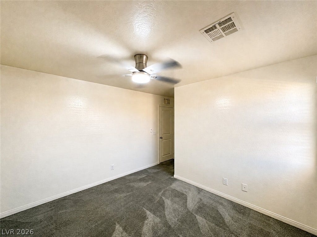 Plush carpeting anchors this versatile room under a smooth textured ceiling.