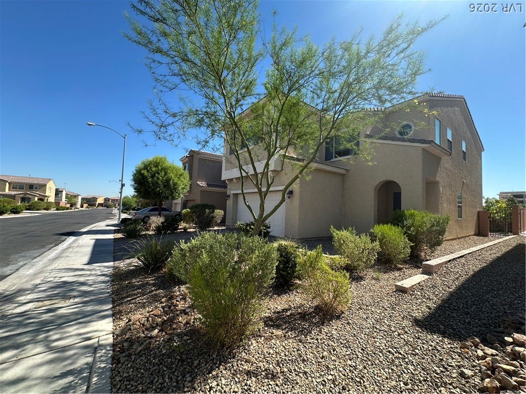 Desert landscaping and stucco finishes frame this multi-level residential structure under clear blue skies.