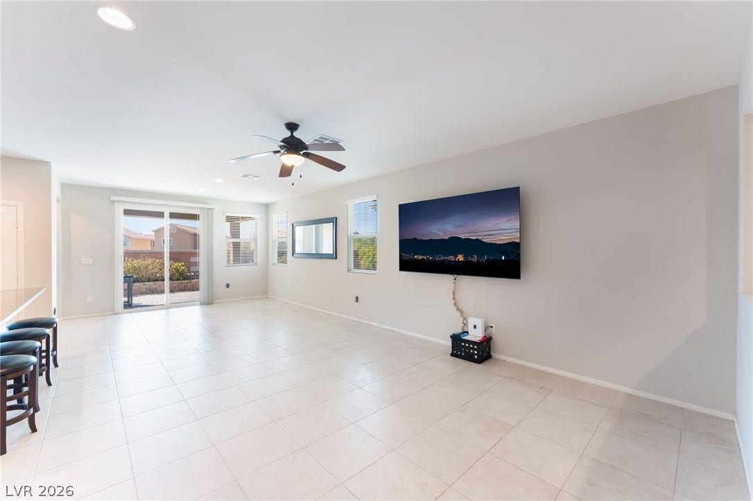Gleaming tile floors and sliding glass doors highlight this airy, open-concept living area.