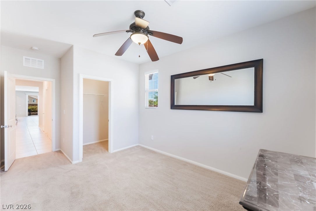 Soft carpeting underfoot and an attached walk-in closet define this versatile secondary bedroom space.