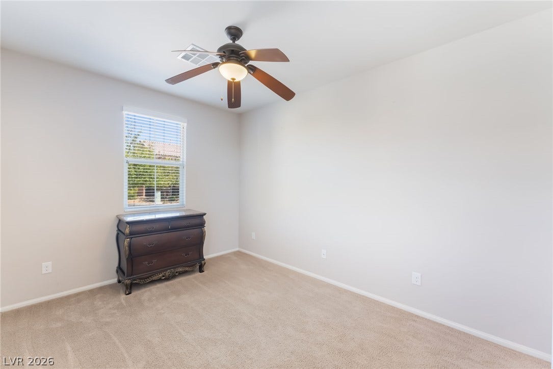 Natural light from a classic window illuminates soft neutral carpeting.