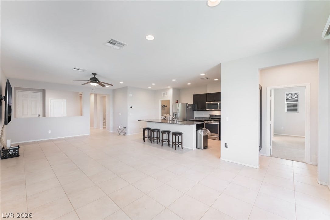 An open layout connects the tiled living space directly to the kitchen.