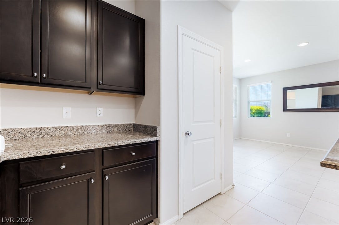 Polished stone countertops complement dark cabinetry in this bright, open interior design.