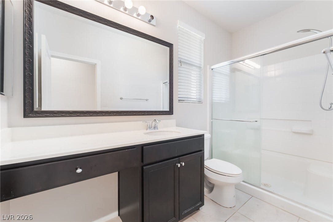 Clean lines and a spacious vanity define this modern bathroom with a glass shower.