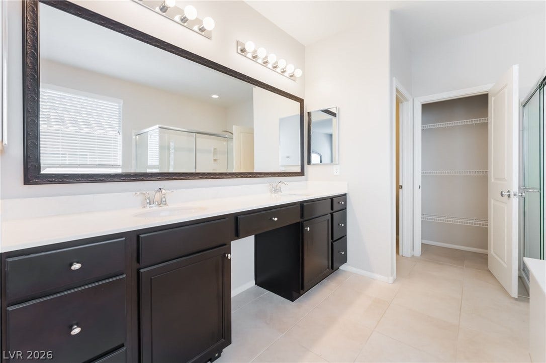 Double vanity sinks and clean tile flooring define this spacious bathroom layout.