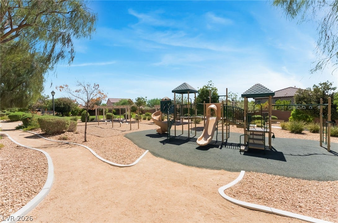 A well-maintained community park offers structured play equipment amidst winding desert-scaped pathways.