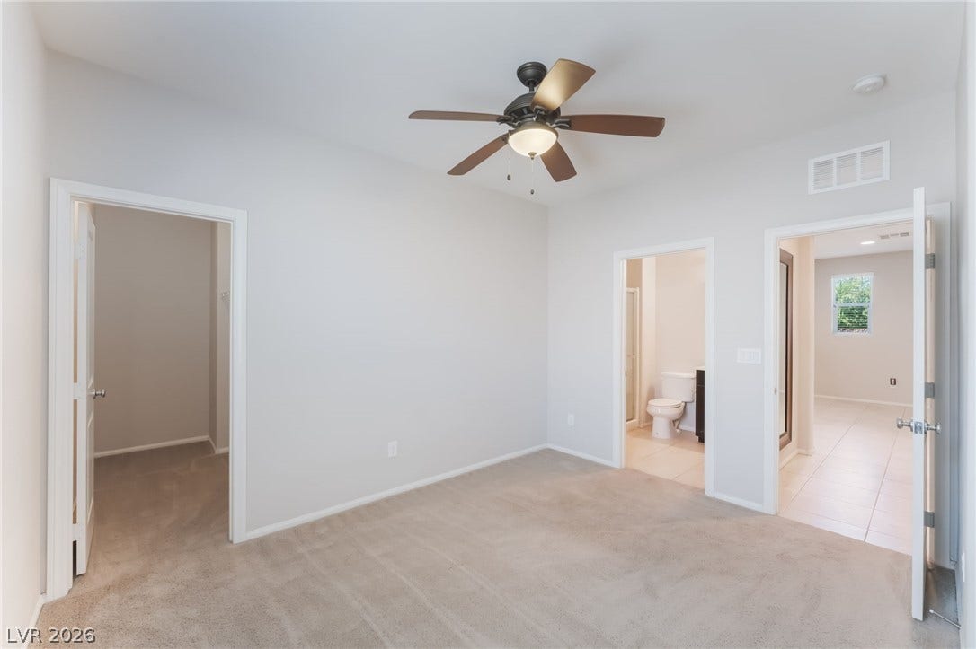 An inviting bedroom features soft carpeting and direct access to an en suite bathroom.