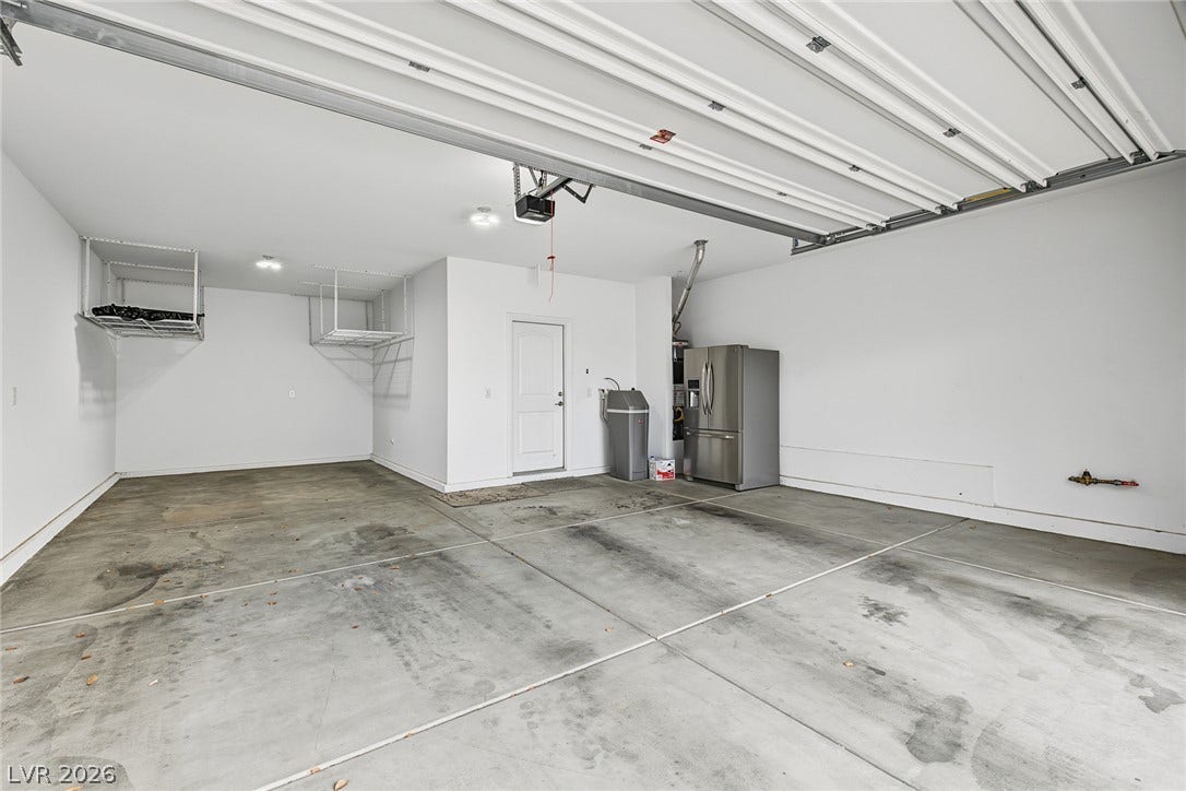 4618 Summer Azure Street, North Las Vegas, NV 89031 An accommodating multi-car garage provides extensive concrete flooring and handy overhead storage racks.