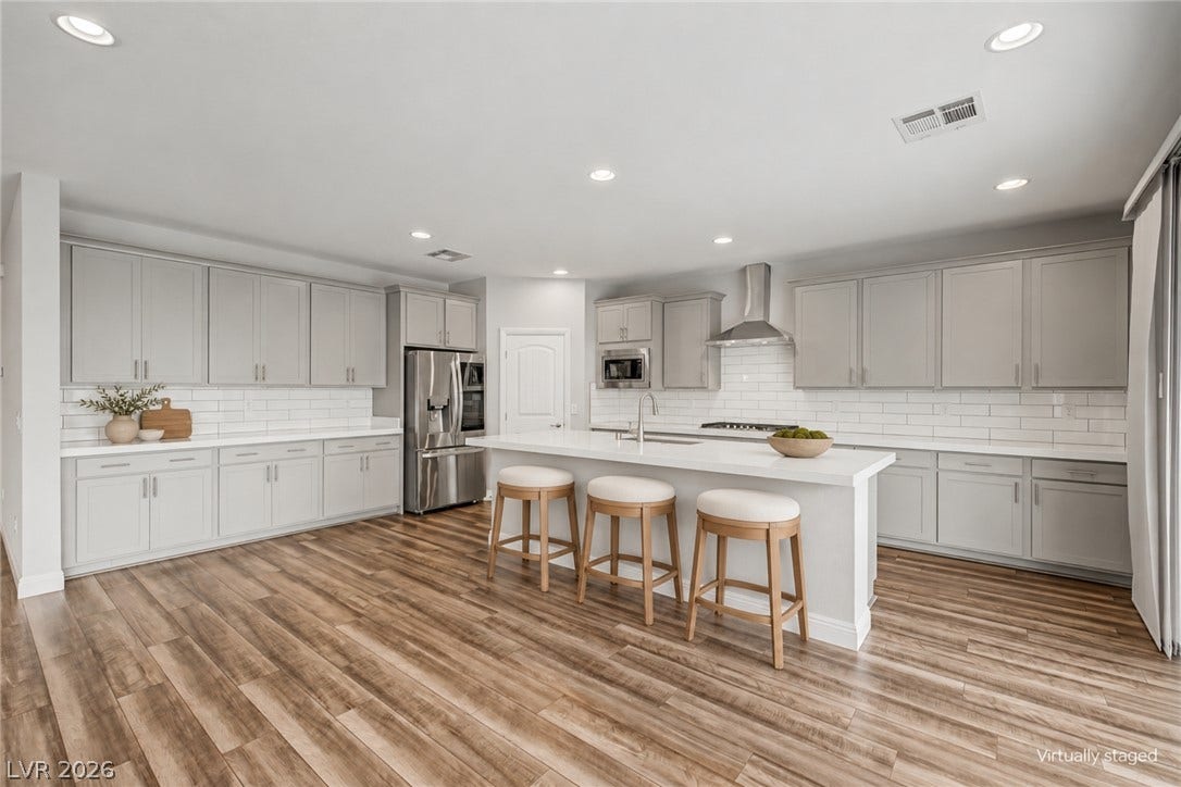 4618 Summer Azure Street, North Las Vegas, NV 89031 Rich wood flooring anchors this sprawling culinary space designed with a central prep island.